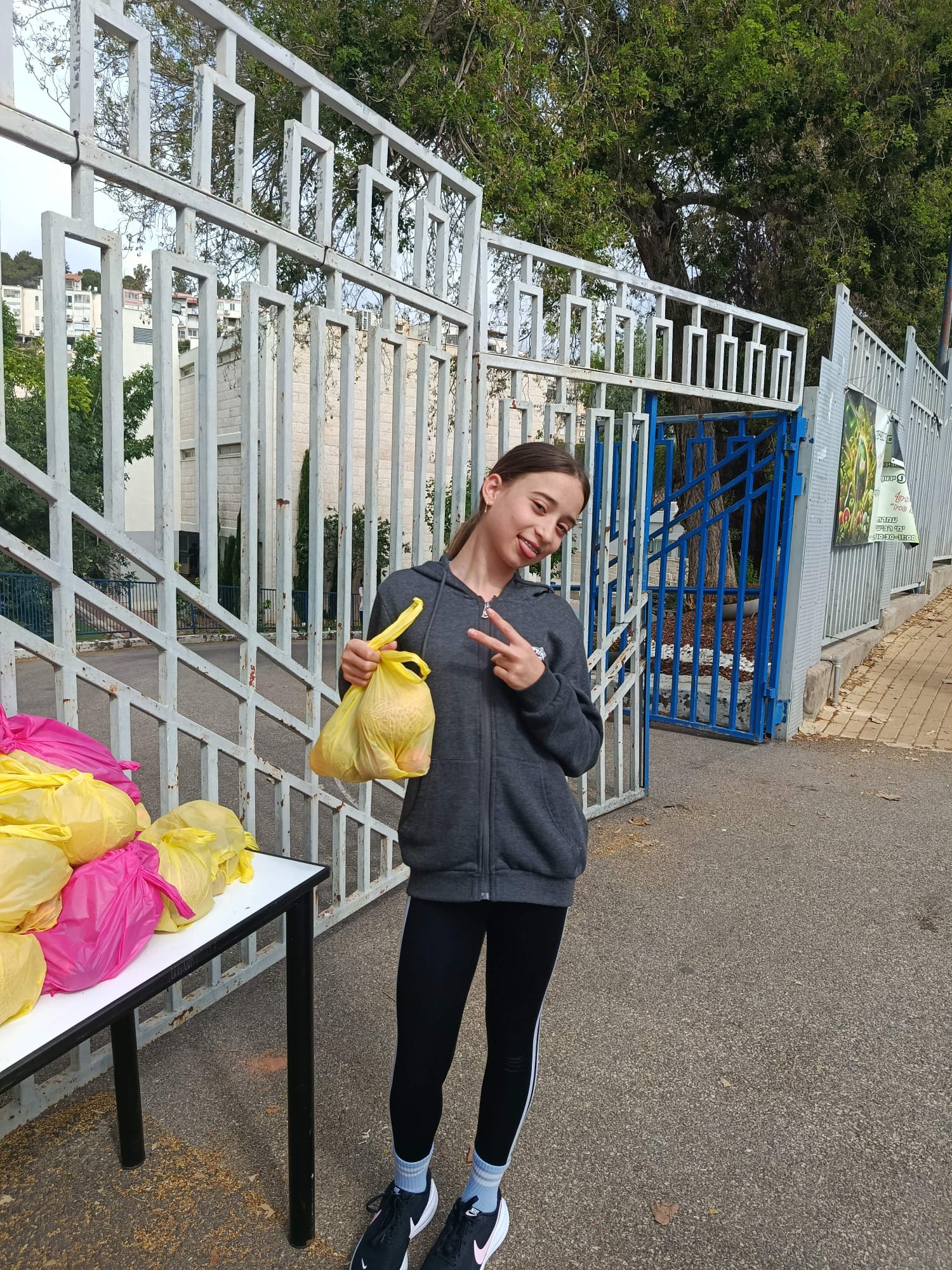 Student holding a bag of produce beside a table of packed bags