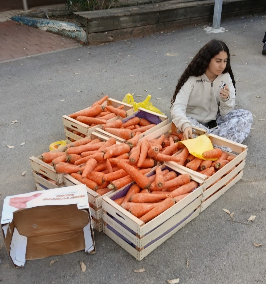 Student beside crates of carrots during a school food rescue activity