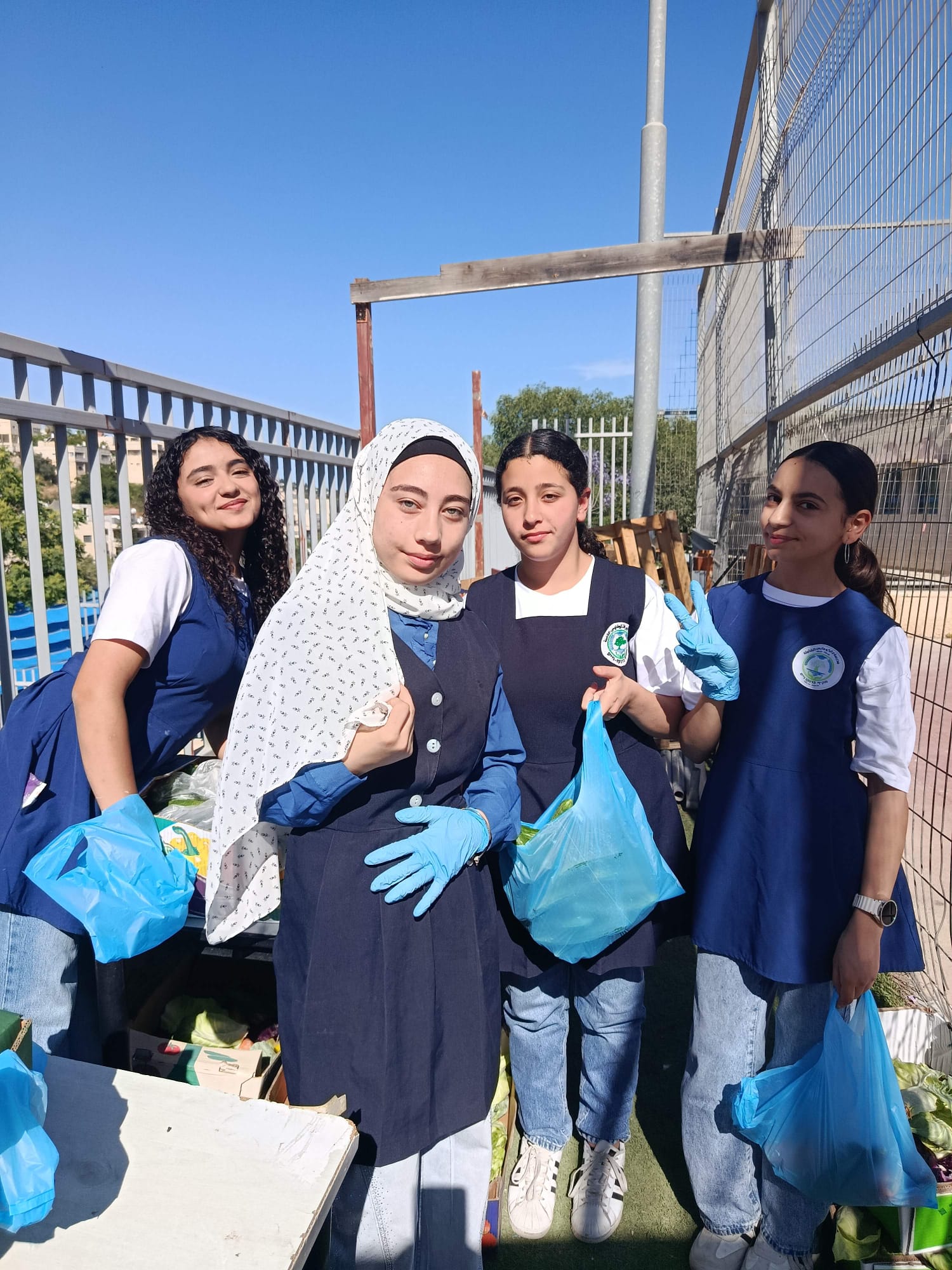 Students holding packed bags of produce at their school